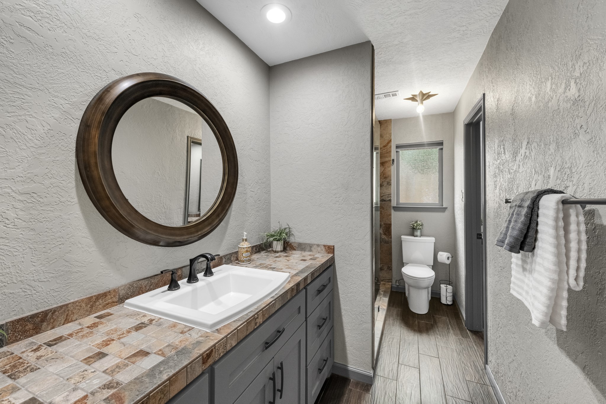 622 South Rivershire Drive Conroe, TX 77304 - Photo 29 of 44 a bathroom with a granite countertop sink a toilet and a mirror