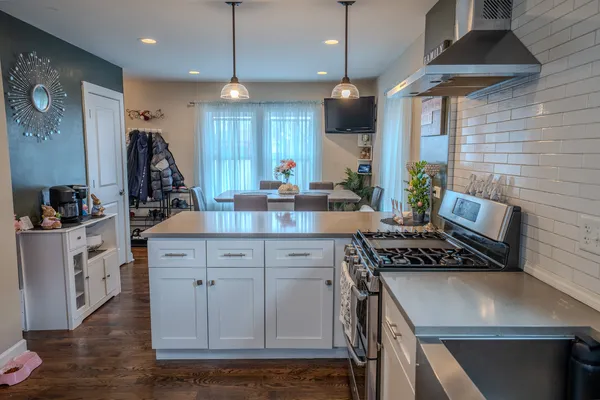 a kitchen with a stove a window and cabinets