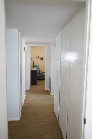 a view of a hallway with a livingroom and a bathroom