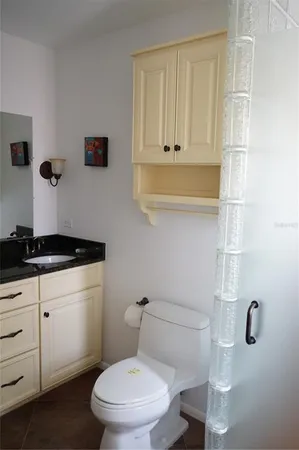 a bathroom with a granite countertop toilet and sink