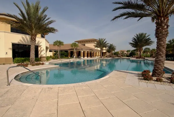 a view of a swimming pool with a patio and a lake view
