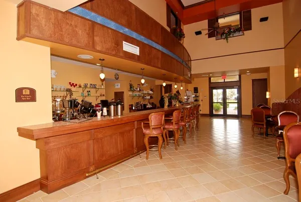 a dining hall with stainless steel appliances kitchen island granite countertop a table chairs in it and a window