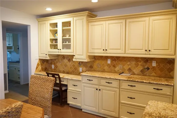 a kitchen with granite countertop white cabinets and sink