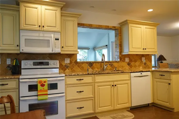 a kitchen with white cabinets and white appliances