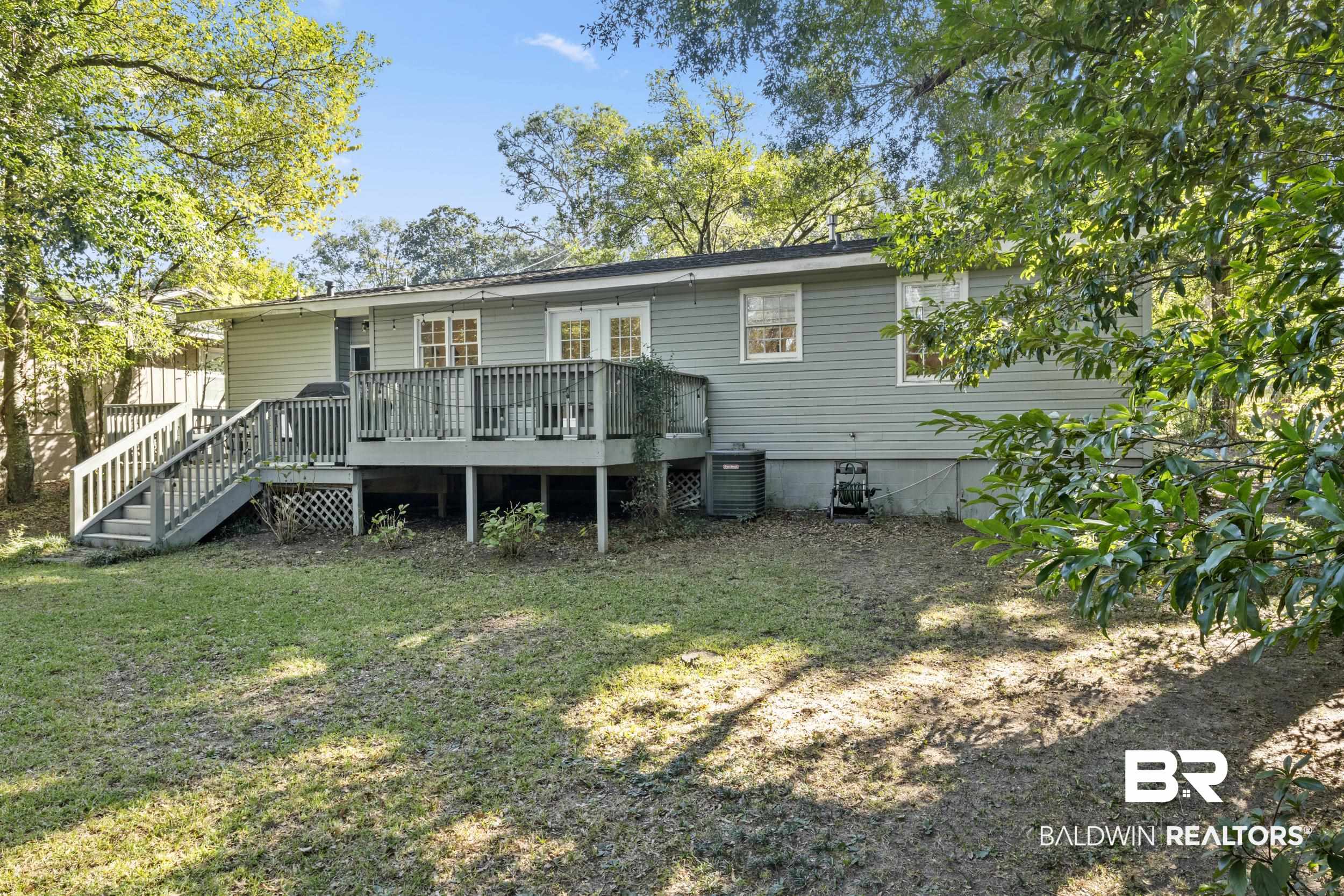 5412 Lusann Drive Mobile, AL 36608 - Photo 6 of 25 Rear view of house with a lawn, a wooden deck, and central AC