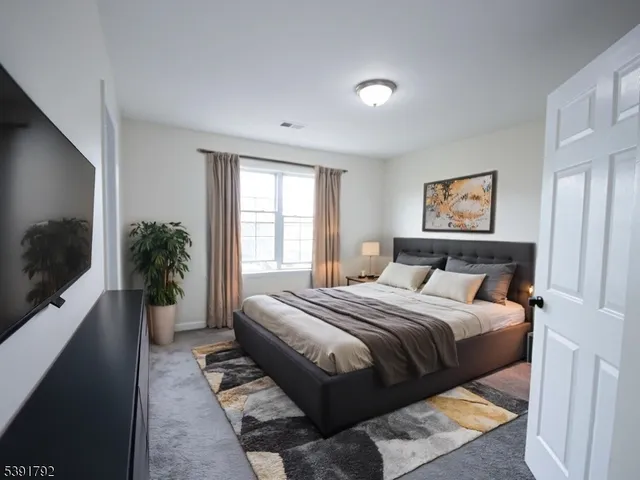 a bedroom with a large bed and a flat screen tv