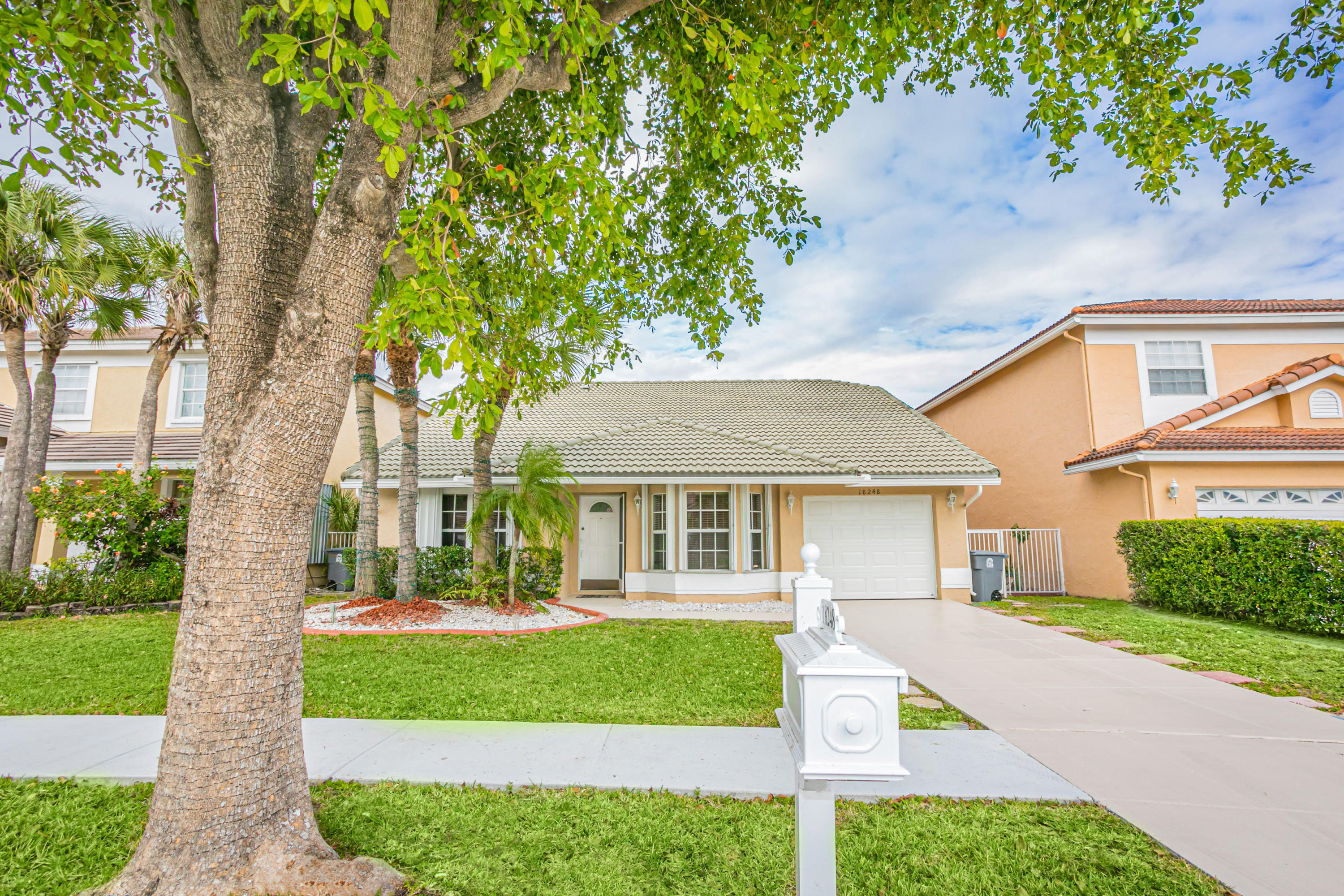 18248 Clear Brook Circle Boca Raton, FL 33498 - Photo 2 of 26 a front view of a house with a yard