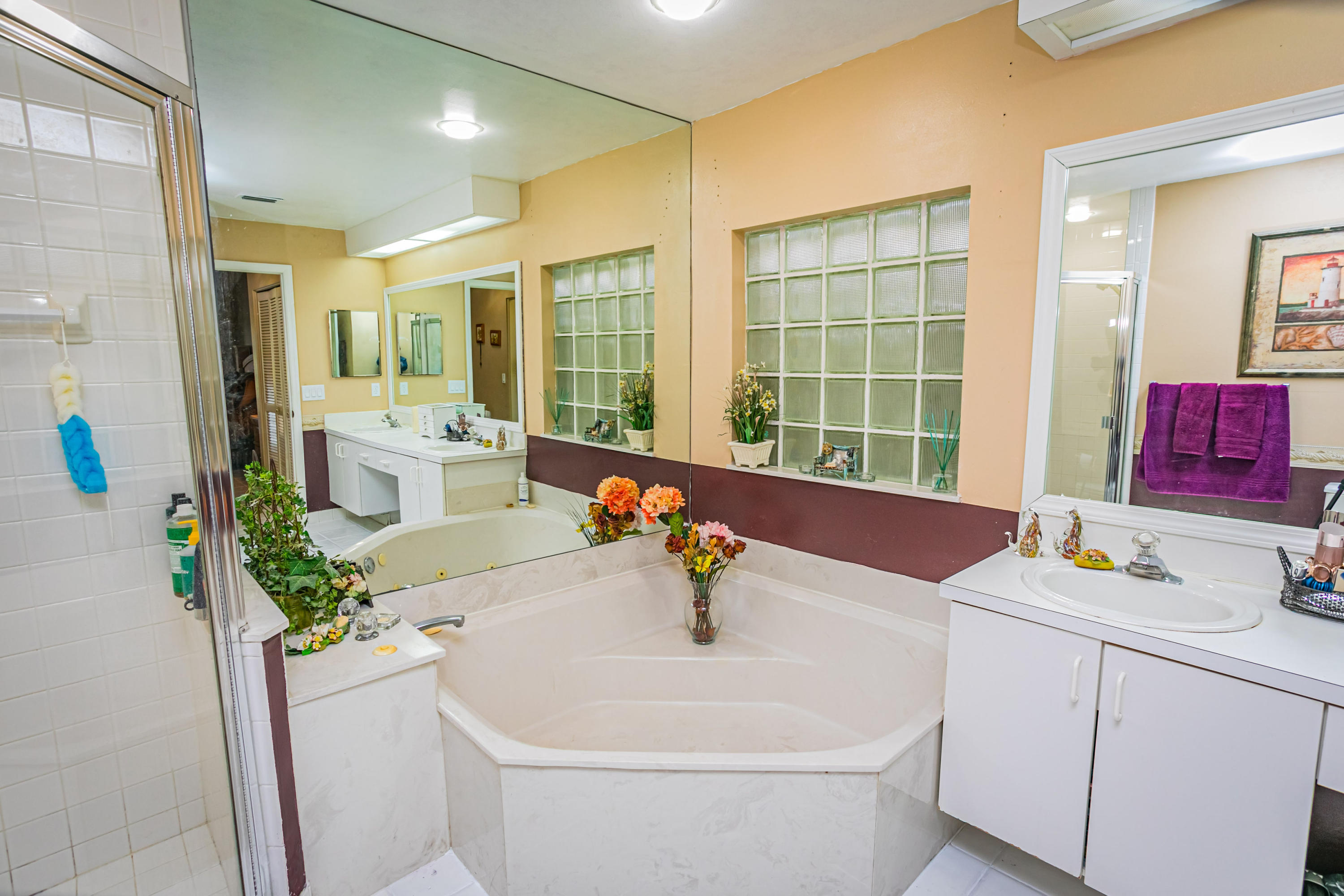 18248 Clear Brook Circle Boca Raton, FL 33498 - Photo 21 of 26 a white bath tub sitting next to a white sink and vanity with wooden floor