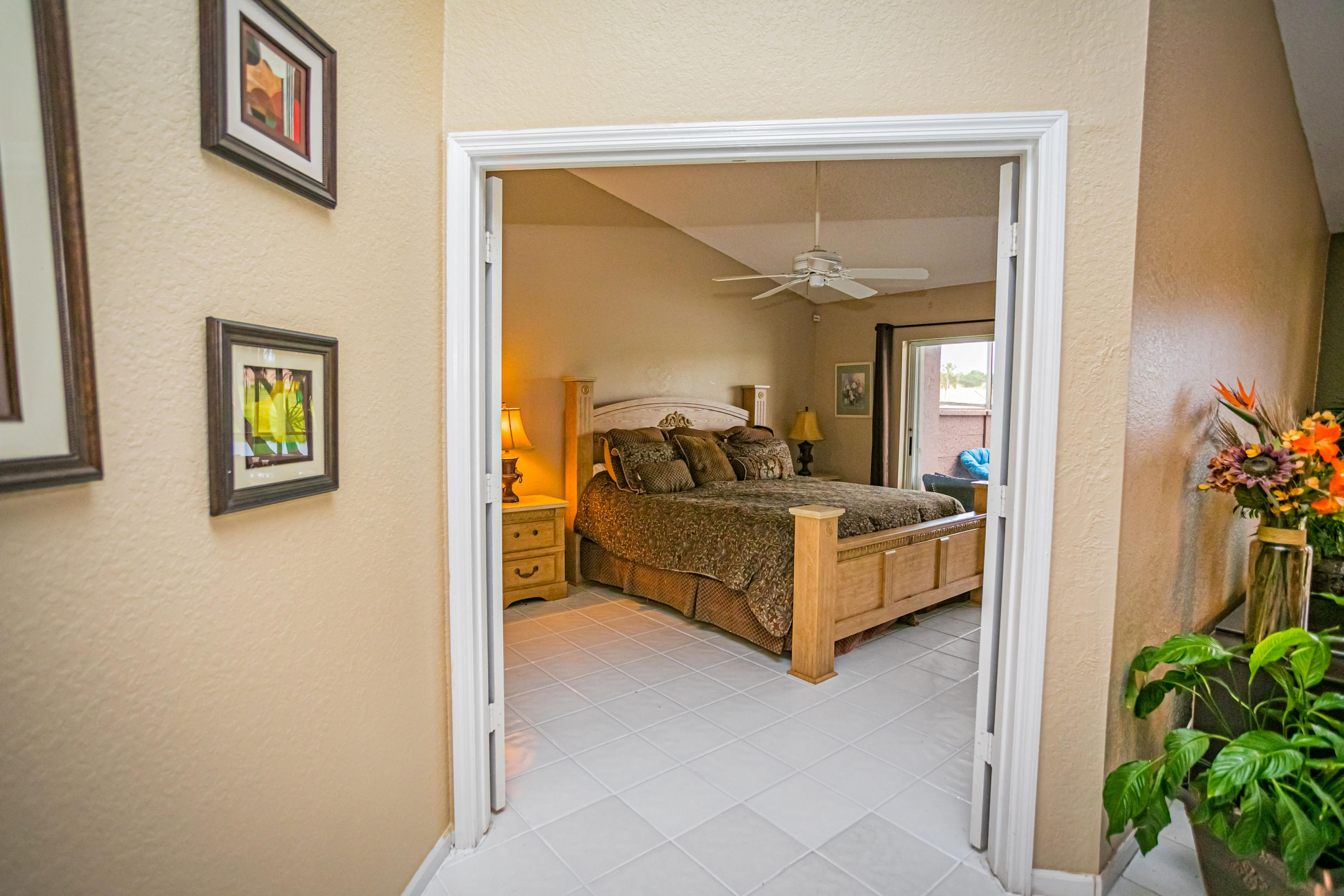 18248 Clear Brook Circle Boca Raton, FL 33498 - Photo 24 of 26 a spacious bedroom with a bed and a potted plant