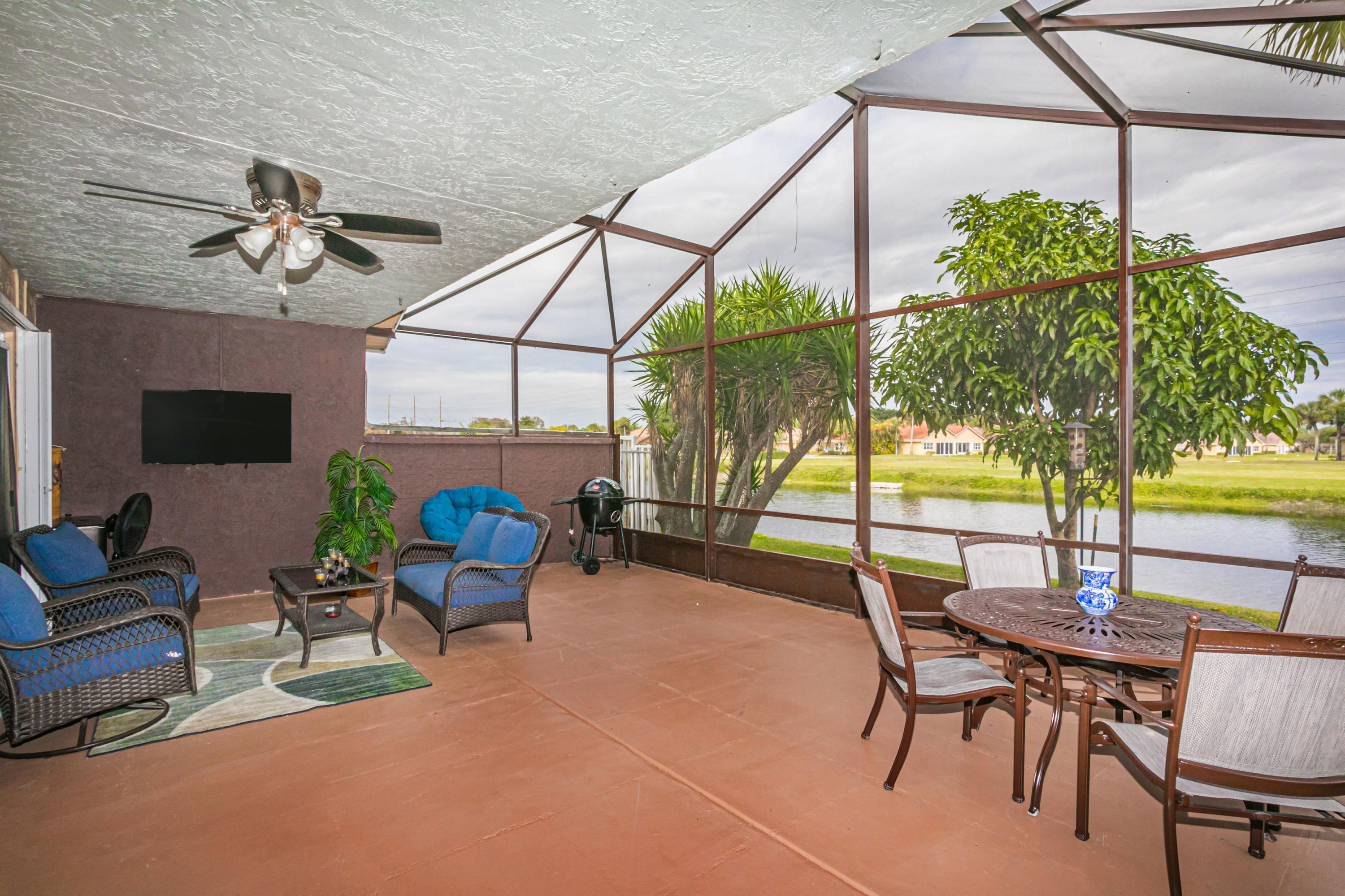 18248 Clear Brook Circle Boca Raton, FL 33498 - Photo 5 of 26 a view of a patio with a table and chairs under an umbrella