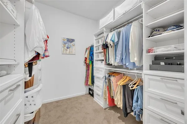 a view of walk in closet with clothes and shoes