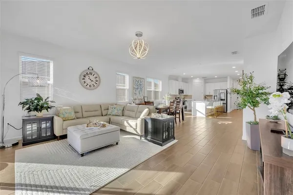 a living room with furniture kitchen view and a potted plant