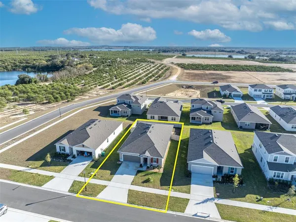 an aerial view of residential houses with outdoor space and ocean view