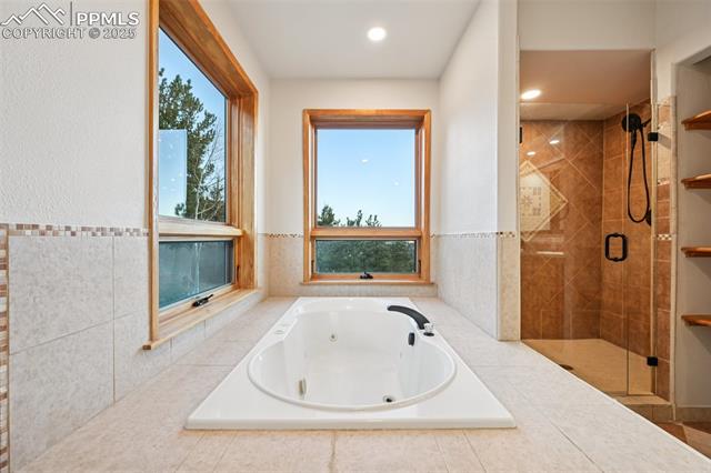 1417 Forest Road Manitou Springs, CO 80829 - Photo 25 of 50 Primary bathroom highlighting the jetted tub with private mountain views out of the windows