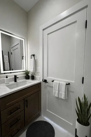 a bathroom with a double vanity sink a mirror and a shower