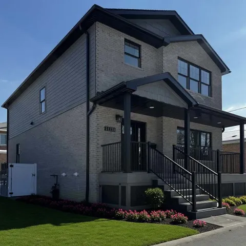 a front view of a house with yard and green space