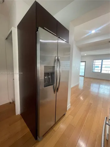 a view of a hallway with wooden floor and a living room