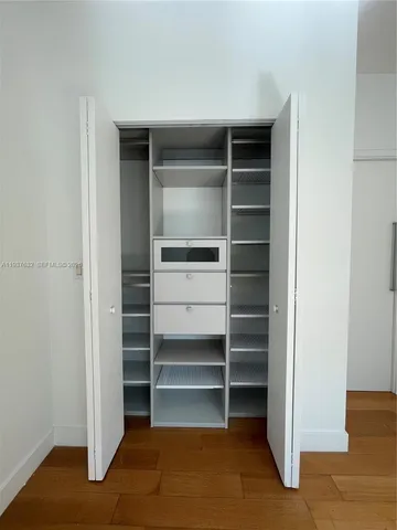 a view of walk in closet with empty racks