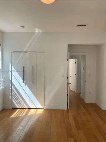 a view of a hallway with wooden floor and entryway