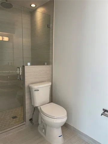 a white toilet sitting next to a shower