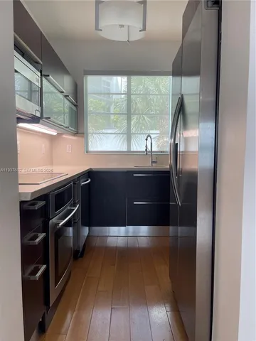 a kitchen with stainless steel appliances granite countertop a sink and a wooden floors