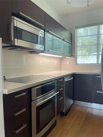 a kitchen with stainless steel appliances a stove microwave and cabinets