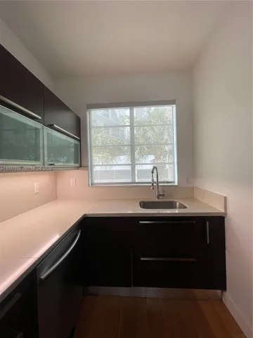 a view of a sink and dishwasher with wooden floor