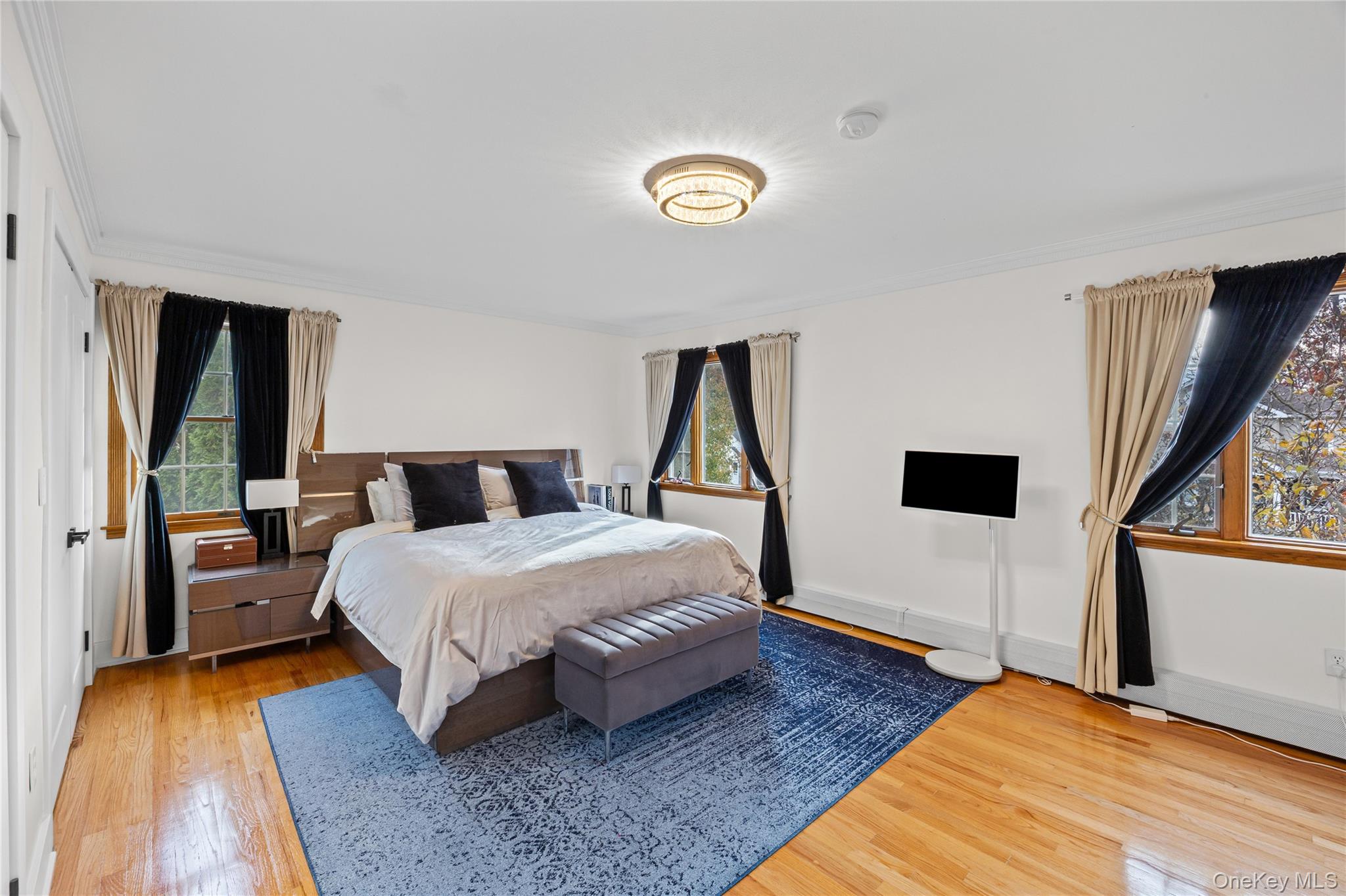 8 Willow Road New Hyde Park, NY 11040 - Photo 13 of 34 a bedroom with a bed and a flat tv screen on dresser