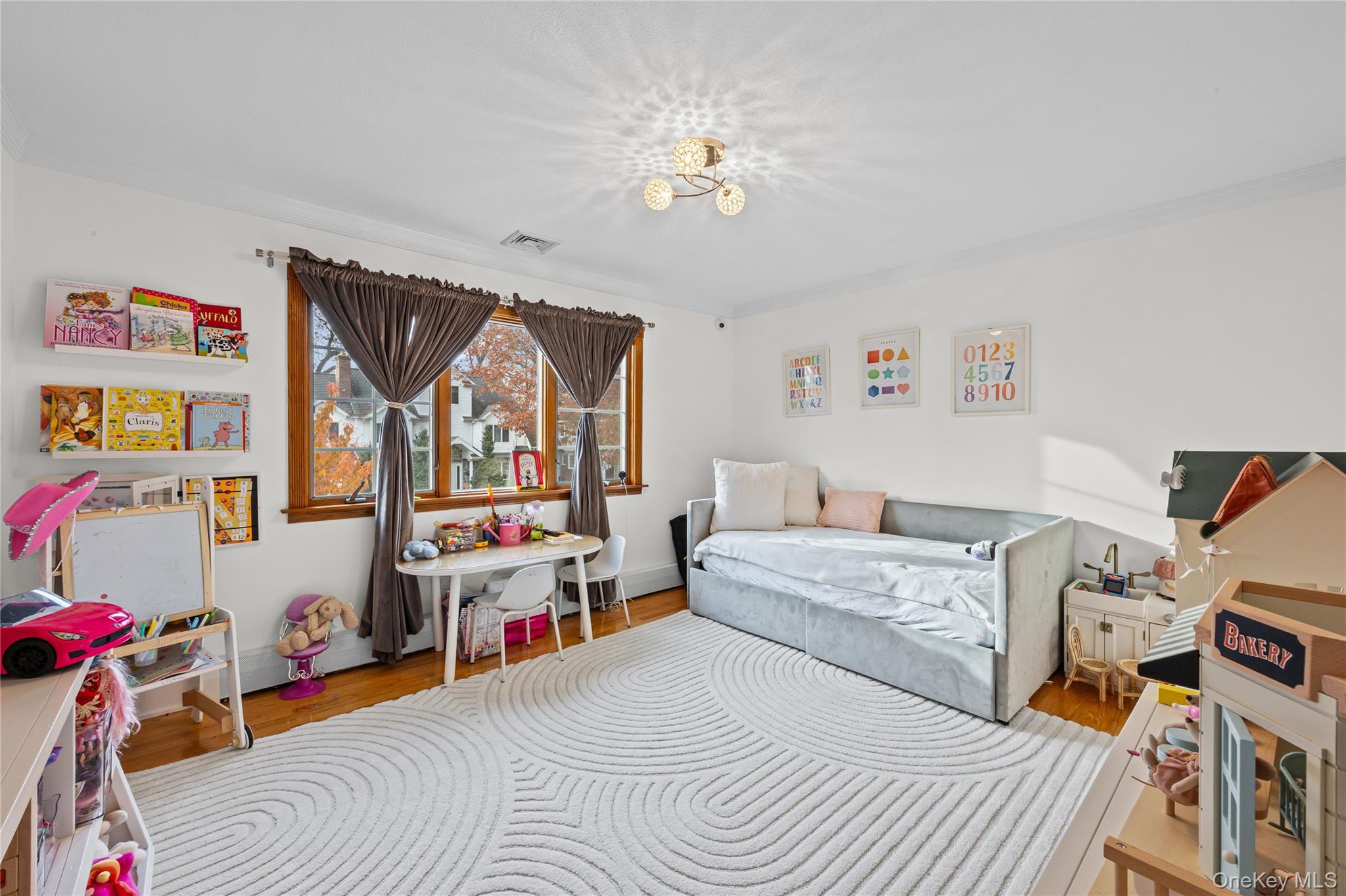 8 Willow Road New Hyde Park, NY 11040 - Photo 16 of 34 a bedroom with a bed and a chandelier