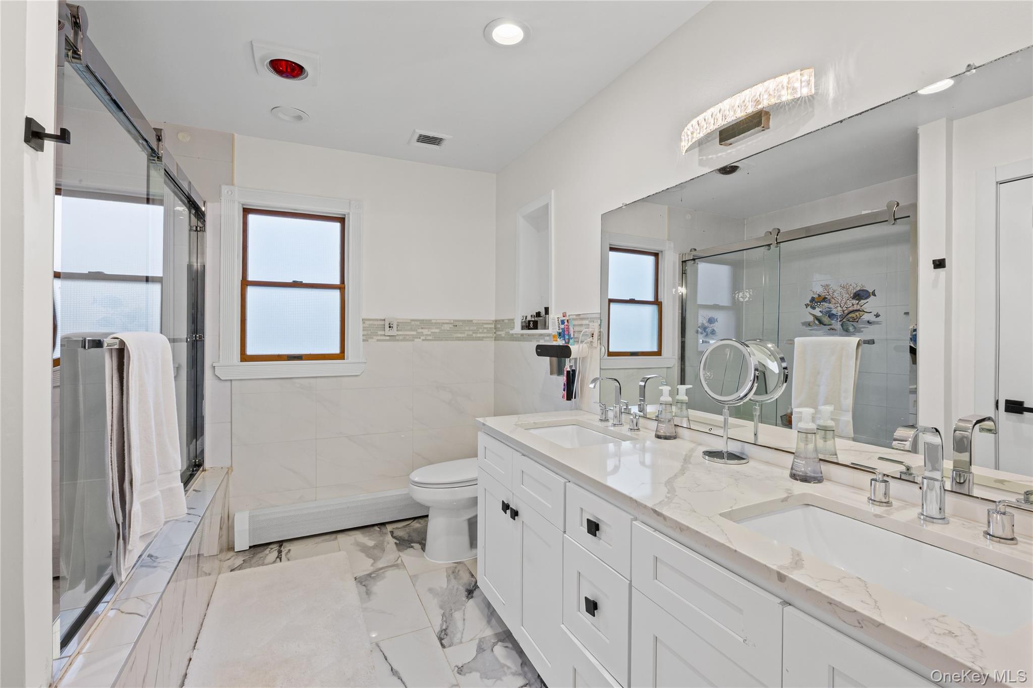 8 Willow Road New Hyde Park, NY 11040 - Photo 18 of 34 a bathroom with double vanity sink a mirror and a shower