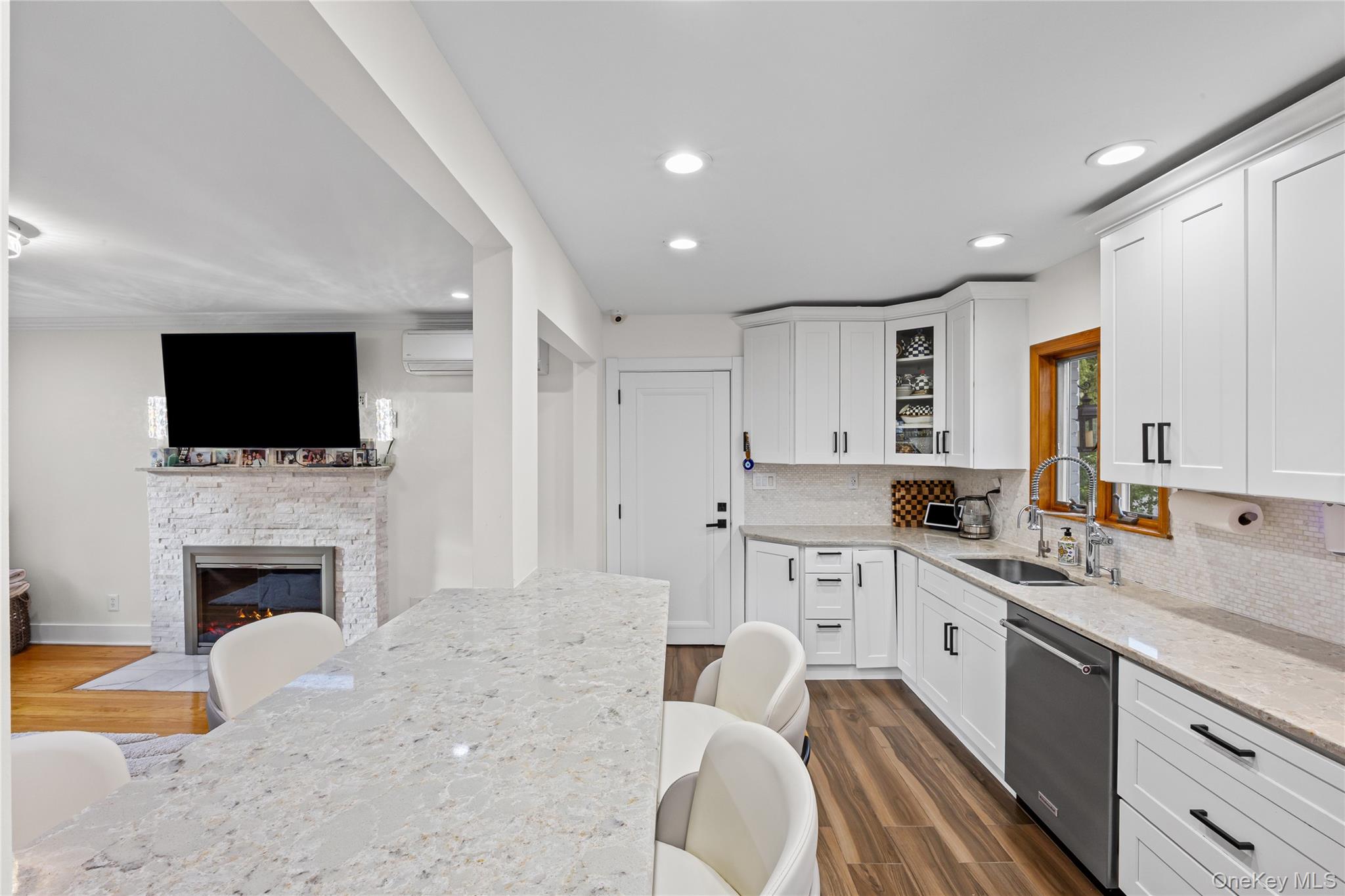 8 Willow Road New Hyde Park, NY 11040 - Photo 6 of 34 a large kitchen with stainless steel appliances a stove a sink dishwasher a microwave oven with white cabinets and a wooden floor