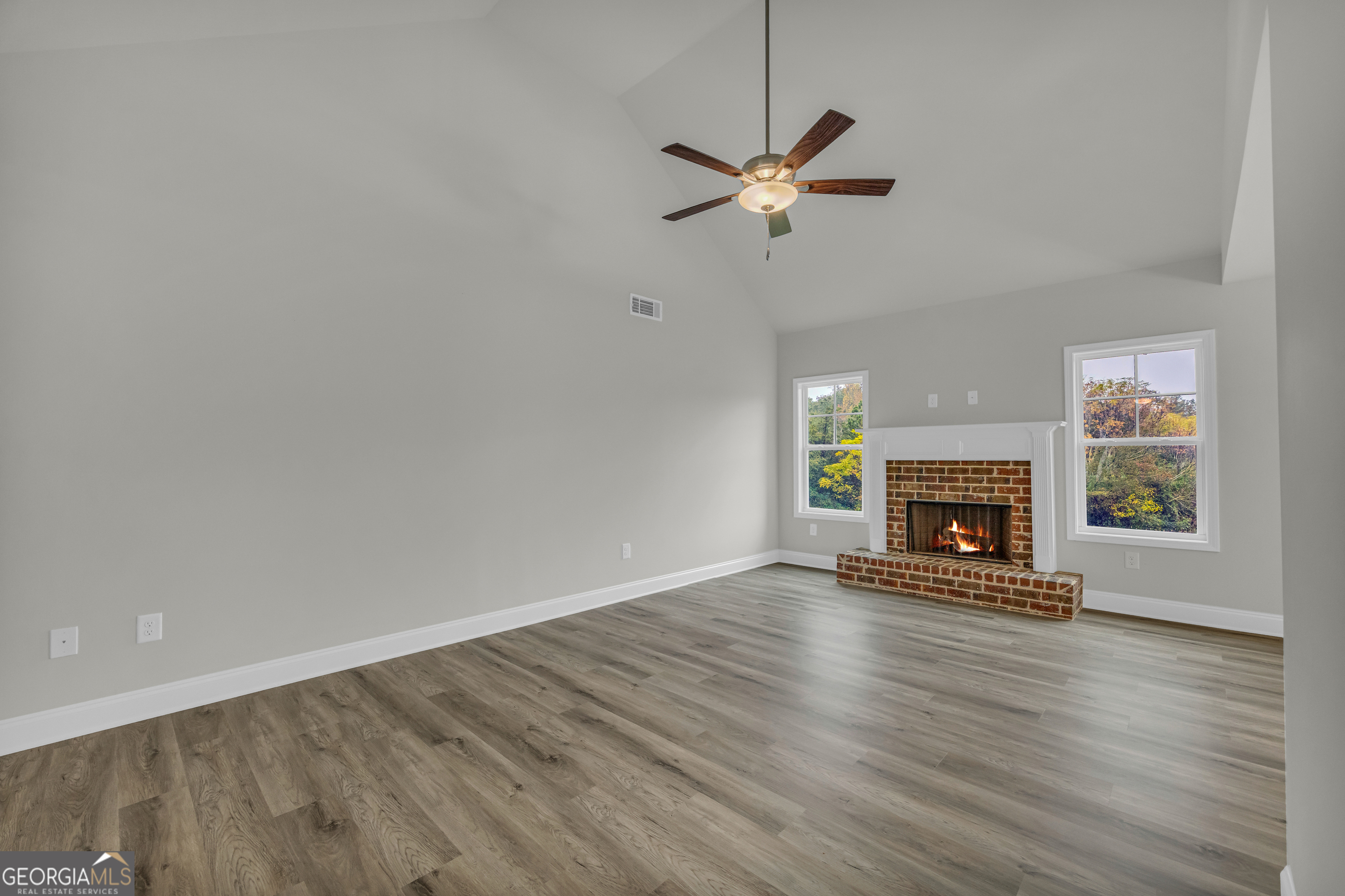 86 Sewell Road Lavonia, GA 30553 - Photo 12 of 67 a view of an empty room with wooden floor fireplace and a window