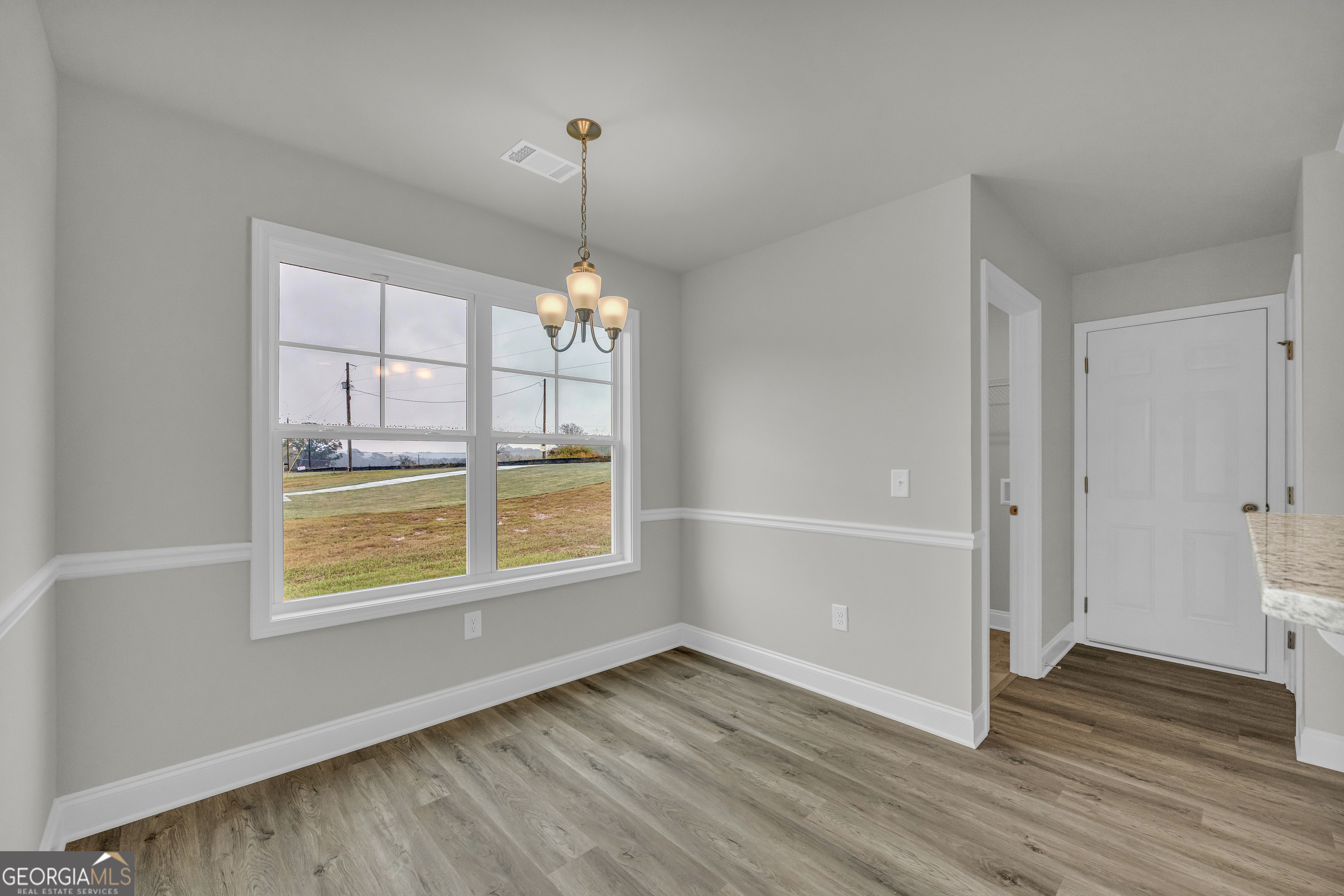86 Sewell Road Lavonia, GA 30553 - Photo 18 of 67 an empty room with wooden floor chandelier and windows