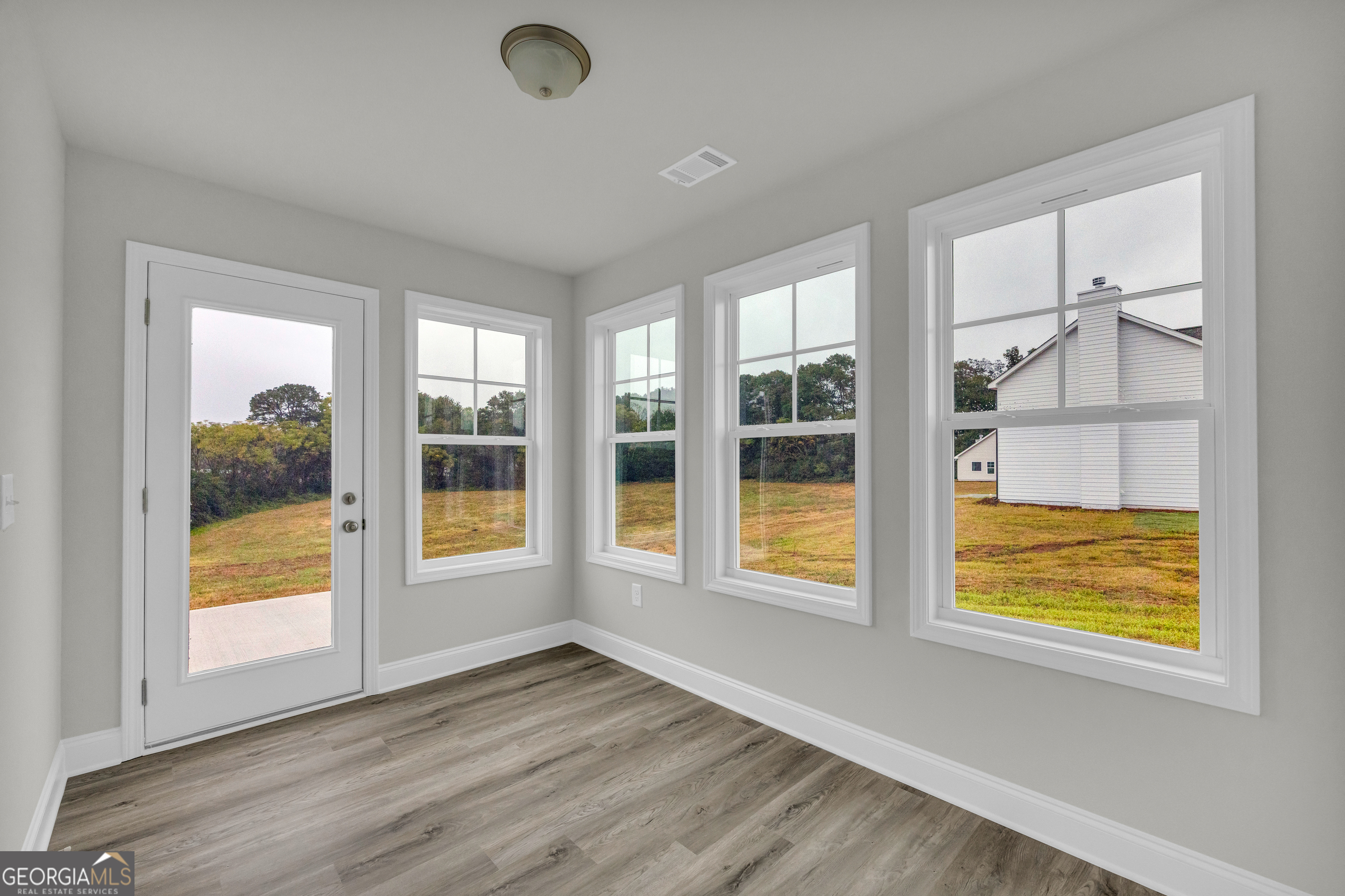 86 Sewell Road Lavonia, GA 30553 - Photo 19 of 67 a view of an empty room with a window and wooden floor