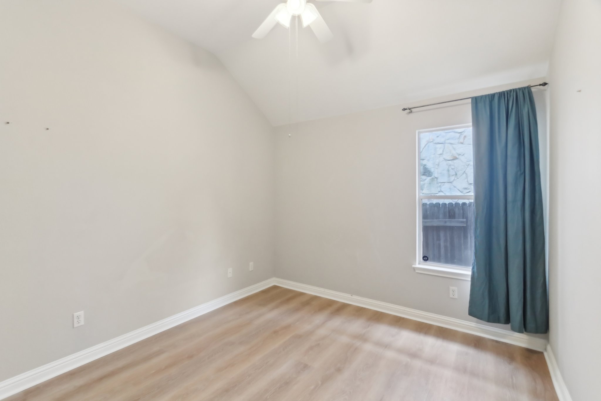10108 Channel Island Drive Austin, TX 78747 - Photo 21 of 36 Empty room with light wood-style floors, a ceiling fan, and lofted ceiling