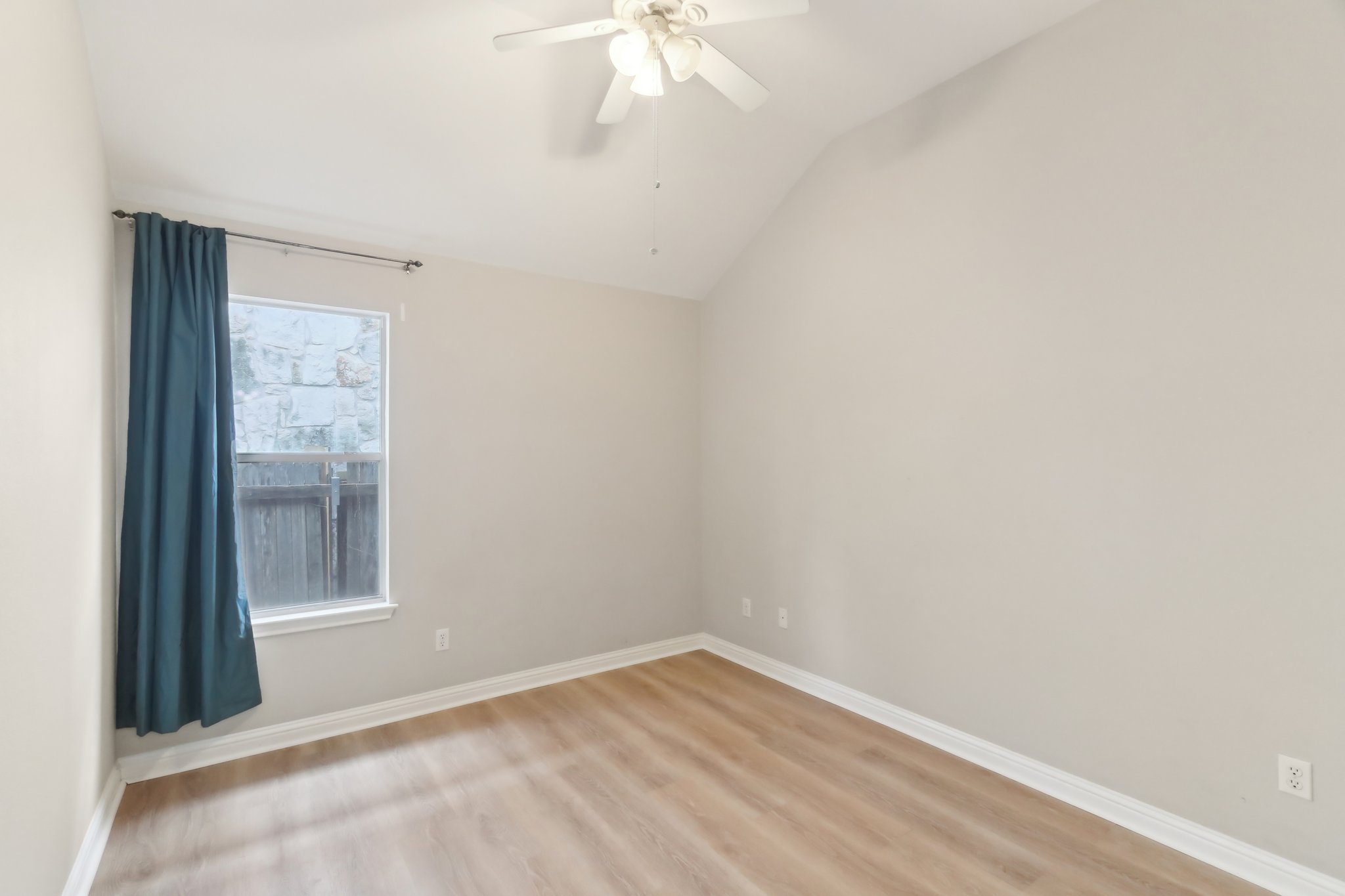 10108 Channel Island Drive Austin, TX 78747 - Photo 22 of 36 Spare room with light wood finished floors, lofted ceiling, and a ceiling fan