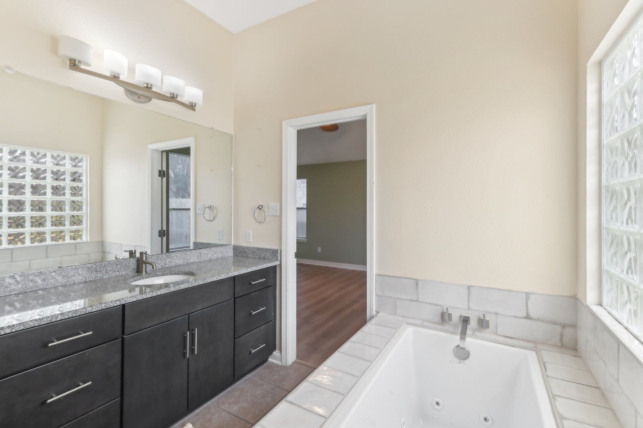 10108 Channel Island Drive Austin, TX 78747 - Photo 32 of 36 Full bathroom featuring vanity, a whirlpool tub, and tile patterned flooring