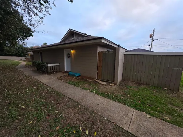a view of a house with backyard and trees