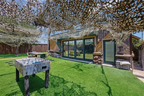 a room with stainless steel appliances kitchen island granite countertop a sink and wooden floors