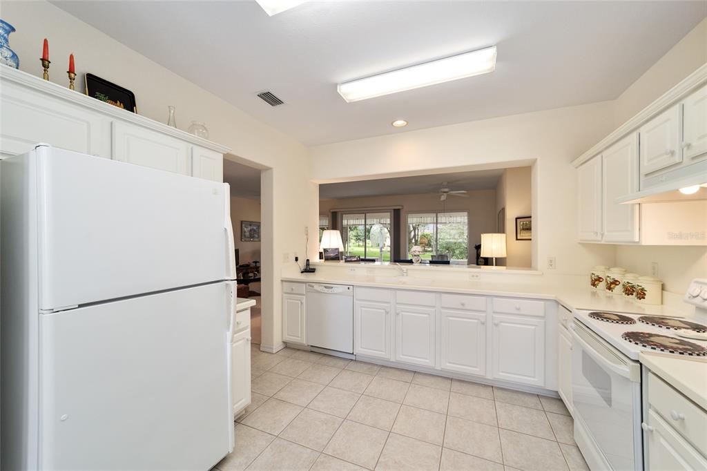 12896 Southeast 91st Terrace Road Summerfield, FL 34491 - Photo 19 of 77 a kitchen with a refrigerator a stove top oven and cabinets