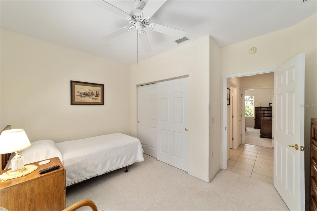 12896 Southeast 91st Terrace Road Summerfield, FL 34491 - Photo 35 of 77 a bedroom with a bed and a chandelier