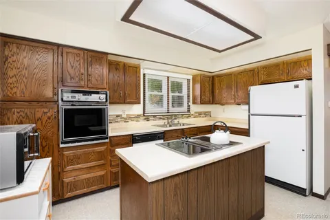 a kitchen with a sink stove top oven and cabinets
