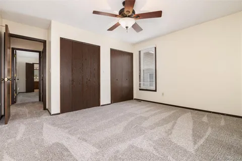 an empty room with window and a ceiling fan