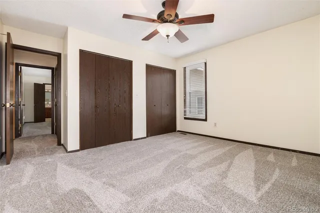 an empty room with window and a ceiling fan