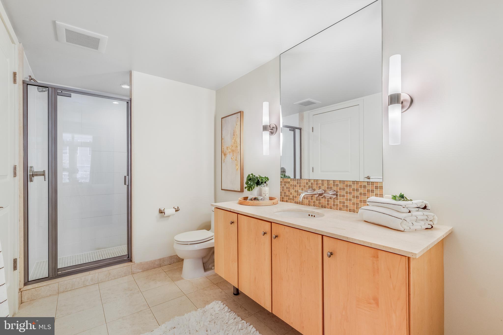 1025 First Street Southeast, Unit 201 Washington, DC 20003 - Photo 18 of 31 a bathroom with a granite countertop sink toilet and shower