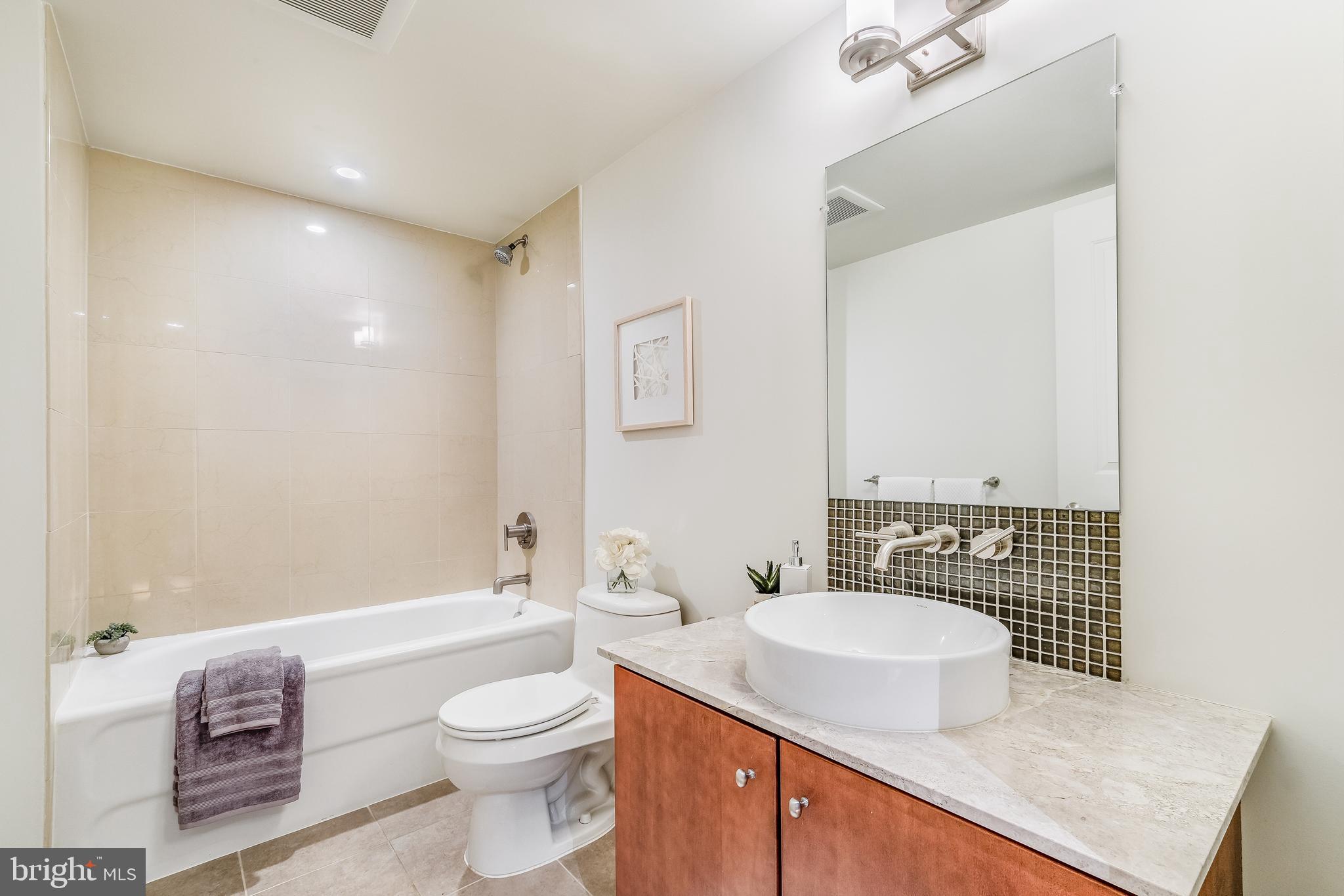 1025 First Street Southeast, Unit 201 Washington, DC 20003 - Photo 22 of 31 a bathroom with a sink toilet vanity and shower