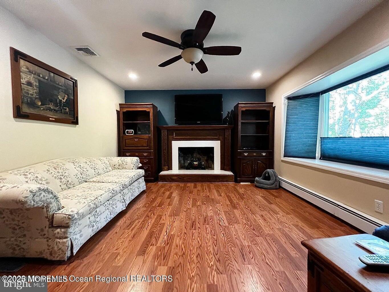 791 Harmony Road Jackson, NJ 08527 - Photo 7 of 16 a living room with furniture flat screen tv and a fireplace