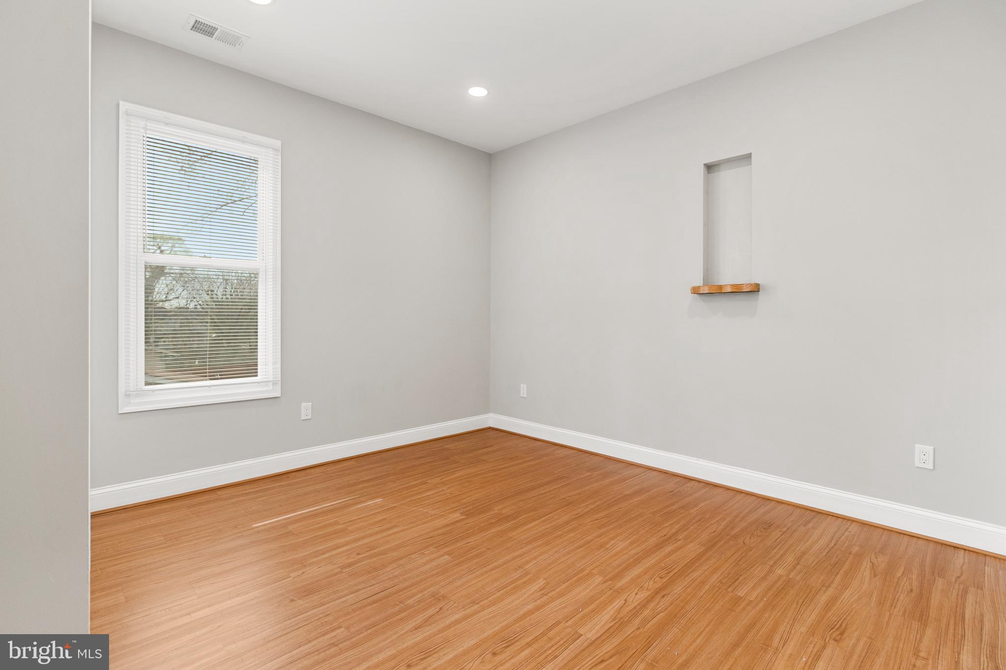 910 Savannah Street Southeast Washington, DC 20032 - Photo 17 of 26 an empty room with wooden floor and windows