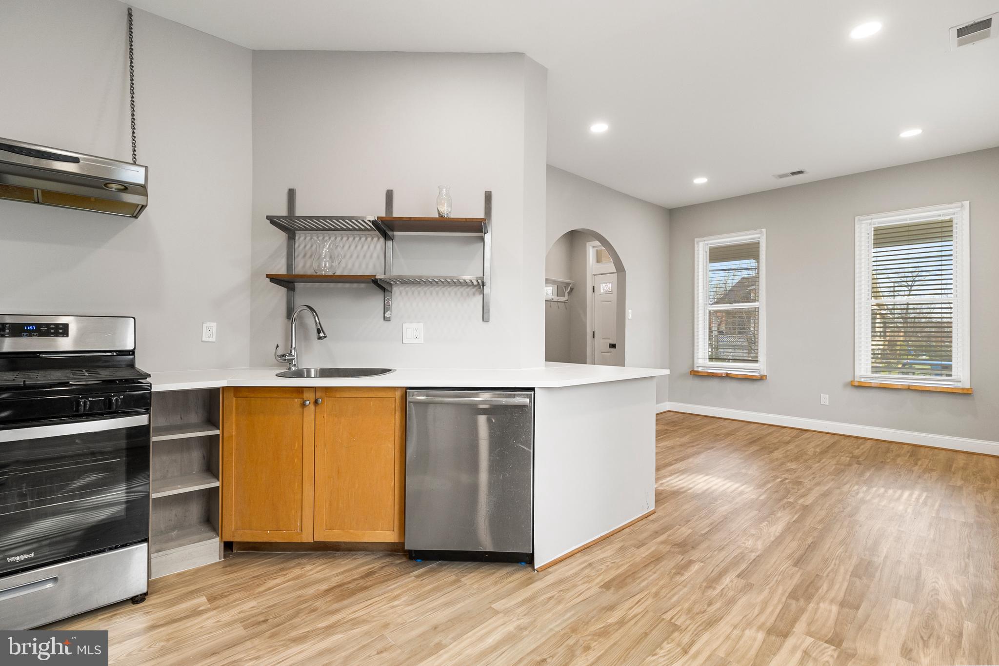 910 Savannah Street Southeast Washington, DC 20032 - Photo 4 of 26 a kitchen with stainless steel appliances granite countertop a sink a stove and wooden floors