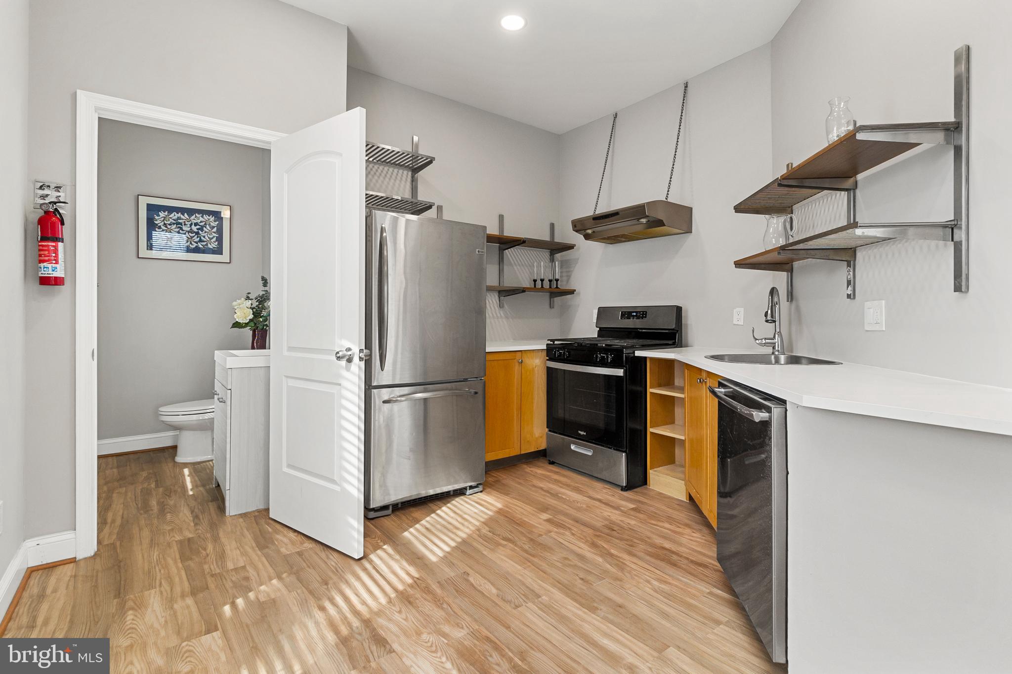 910 Savannah Street Southeast Washington, DC 20032 - Photo 5 of 26 a kitchen with stainless steel appliances granite countertop a refrigerator a sink a stove and oven with wooden floor